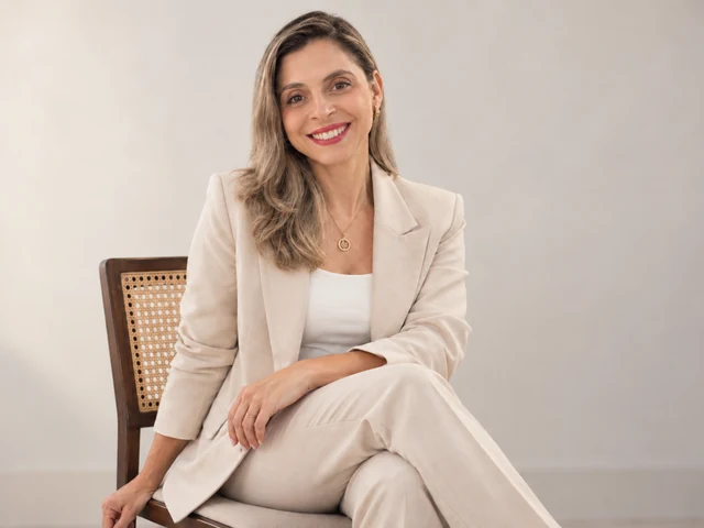 Daniele Pulcelli sorrindo, sentada em uma cadeira de madeira